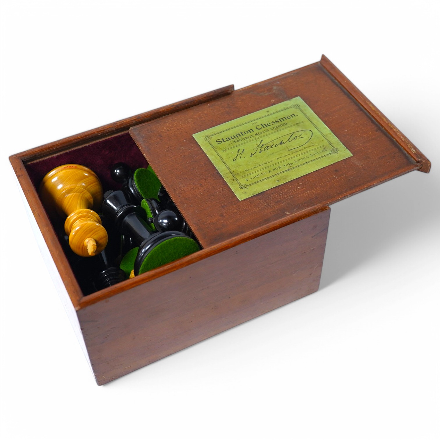 An early 20th century boxed J. Jaques & Son Staunton chess set, ebony and boxwood pieces, contained within the original velvet lined teak box with sliding lid and paper label to lid with facsimile of Howard Staunton sign